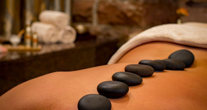 Ambiance de d&eacute;tente avec pierres chaudes dans une chambre avec jacuzzi privatif.