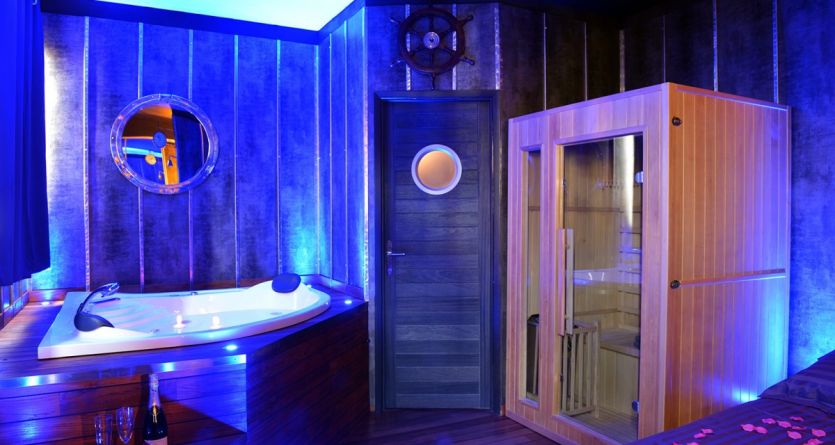 Jacuzzi et sauna dans une chambre &agrave; th&egrave;me nautique, promesse d'une nuit d'&eacute;vasion.